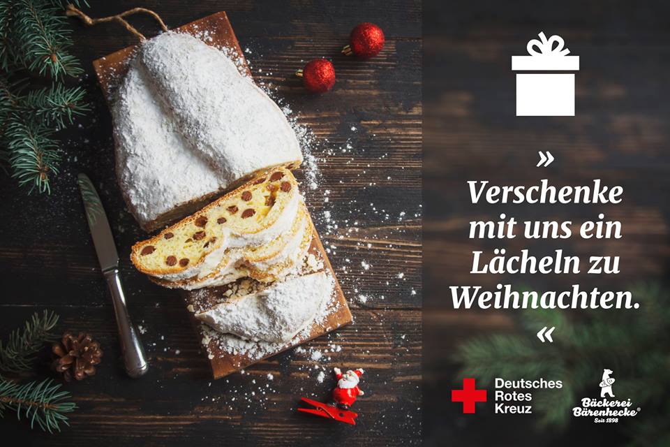 Ein aufgeschnittener Rosinenstollen liegt auf einem Holzbrett. Er wurde mit einer großen Menge Puderzucker verziert.