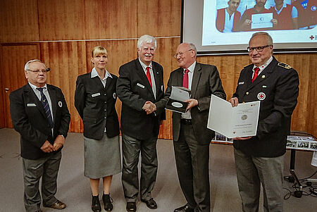 5 Personen mit bei einer Veranstaltung halten eine Urkunde