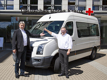 Übergabe des Schlüssels vor dem Transporter